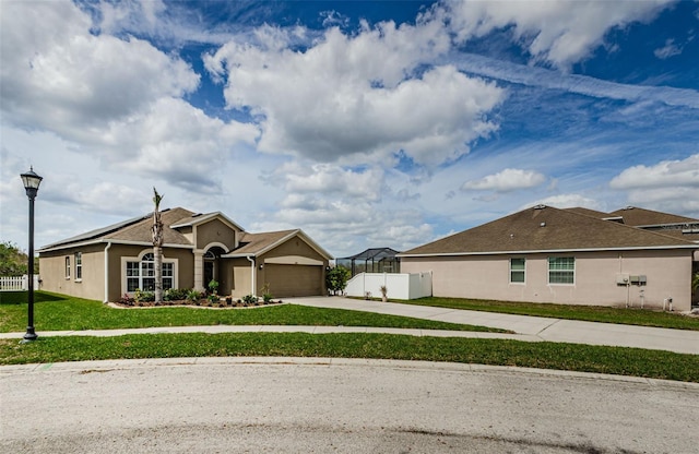 view of front facade featuring a garage, driveway, fence, and stucco siding