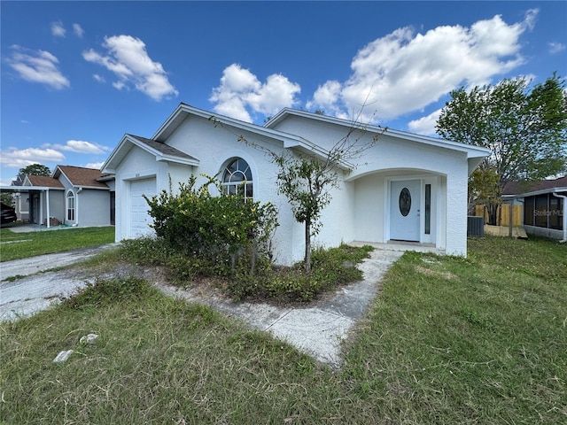 view of front of house featuring a garage, a front yard, and stucco siding