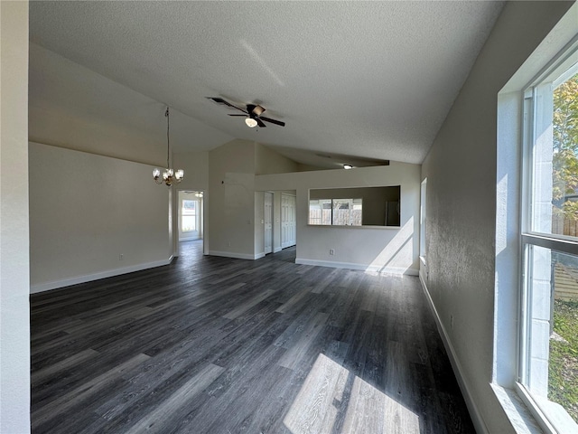 unfurnished living room featuring dark wood-style floors, vaulted ceiling, plenty of natural light, and a textured ceiling