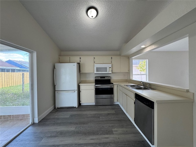 kitchen featuring dark wood-style floors, appliances with stainless steel finishes, light countertops, a textured ceiling, and a sink