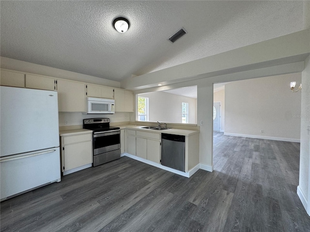 kitchen with light countertops, visible vents, appliances with stainless steel finishes, vaulted ceiling, and a sink