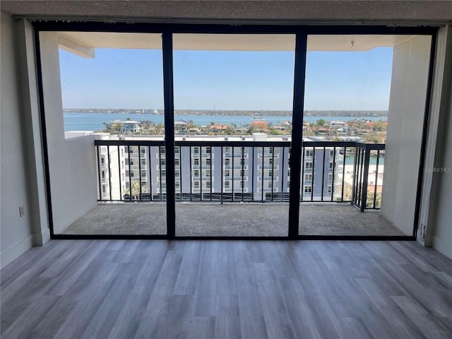 balcony featuring a water view and a city view