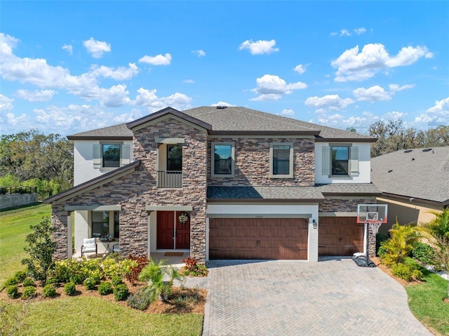 view of front of home featuring an attached garage, stone siding, roof with shingles, decorative driveway, and stucco siding