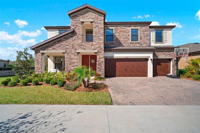 view of front of home with stone siding, decorative driveway, a garage, and stucco siding