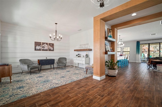 sitting room featuring wood tiled floor, baseboards, and an inviting chandelier