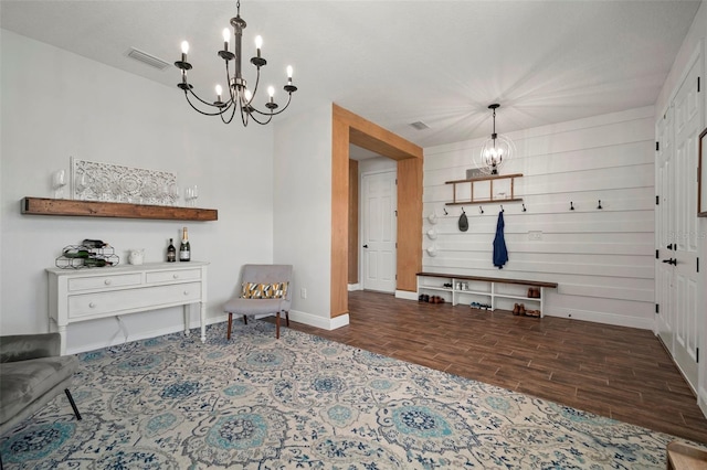 living area featuring an inviting chandelier, baseboards, visible vents, and wood finish floors