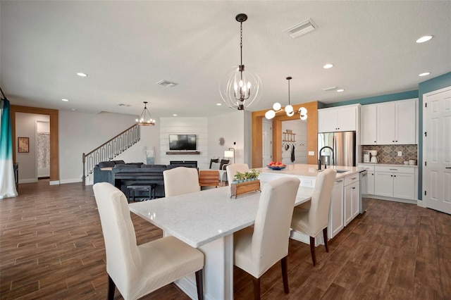 dining room featuring recessed lighting, visible vents, stairs, dark wood-style floors, and an inviting chandelier