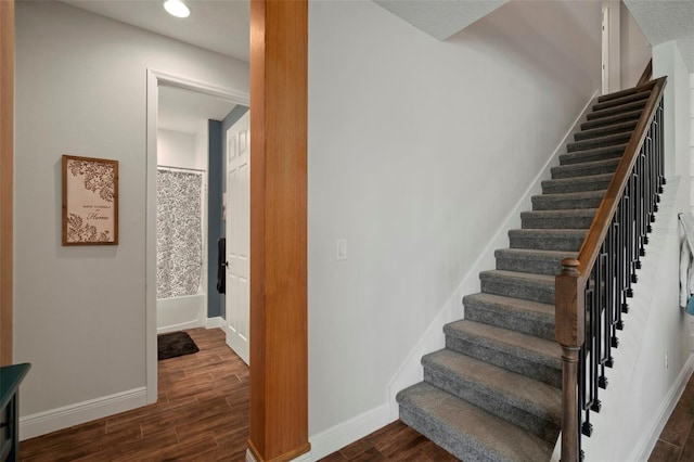 stairway with baseboards and wood finished floors