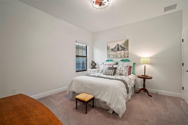 carpeted bedroom featuring a textured ceiling, visible vents, and baseboards