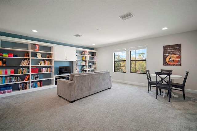 living area with a textured ceiling, recessed lighting, light colored carpet, visible vents, and baseboards