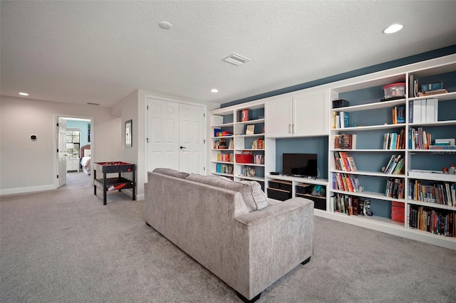 living area with baseboards, visible vents, light colored carpet, a textured ceiling, and recessed lighting