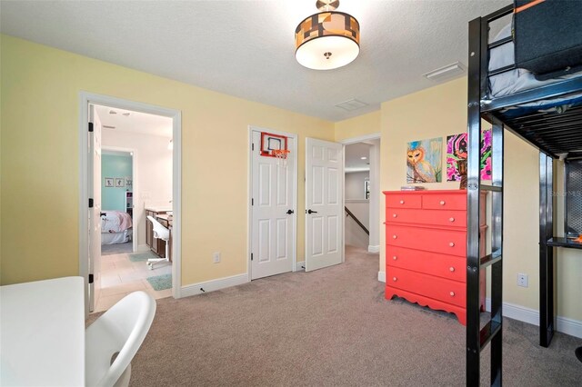 bedroom with a textured ceiling, carpet flooring, and baseboards