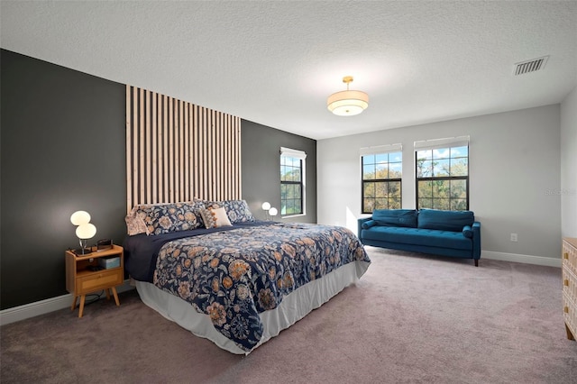 carpeted bedroom featuring visible vents, a textured ceiling, and baseboards