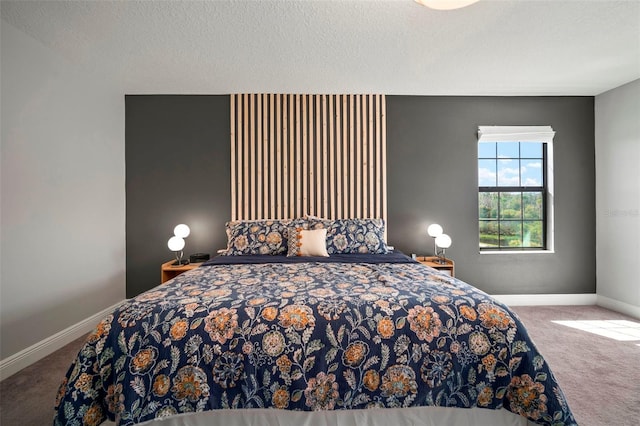 bedroom with a textured ceiling, carpet flooring, and baseboards