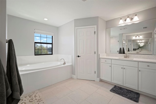 full bathroom featuring visible vents, a garden tub, vanity, and tile patterned floors