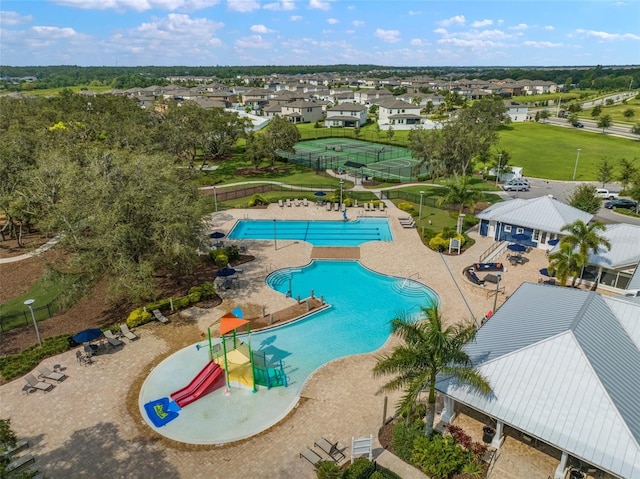 community pool with a residential view, a patio, and fence