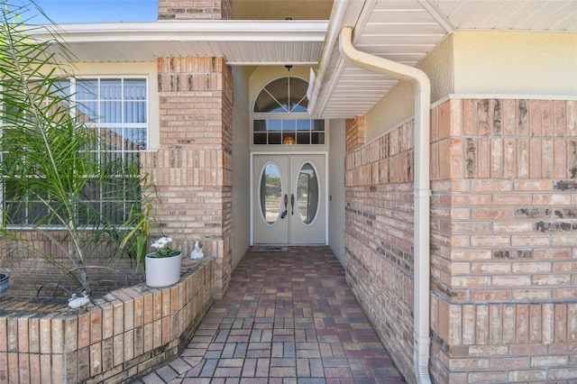 entrance to property featuring french doors and brick siding