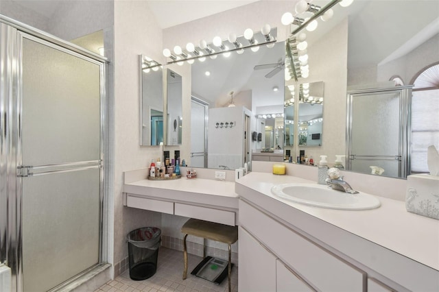 bathroom featuring tile patterned flooring, vaulted ceiling, a shower stall, and vanity