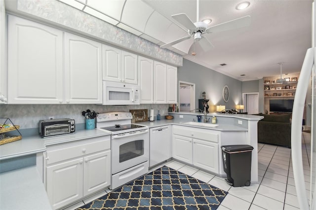 kitchen with open floor plan, white cabinets, a sink, white appliances, and a peninsula