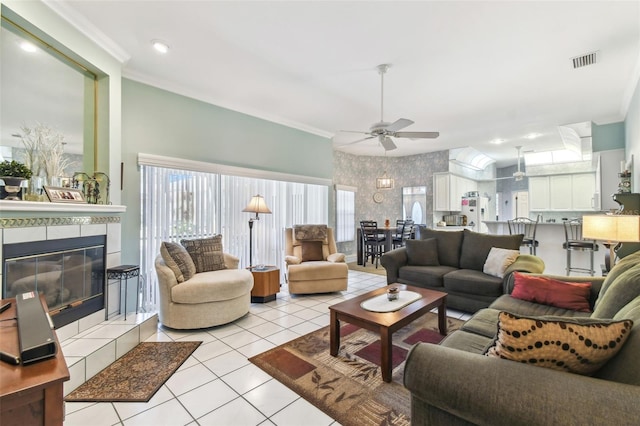 living room with wallpapered walls, light tile patterned floors, visible vents, and ornamental molding