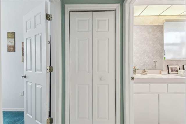 bathroom featuring baseboards, a closet, and vanity