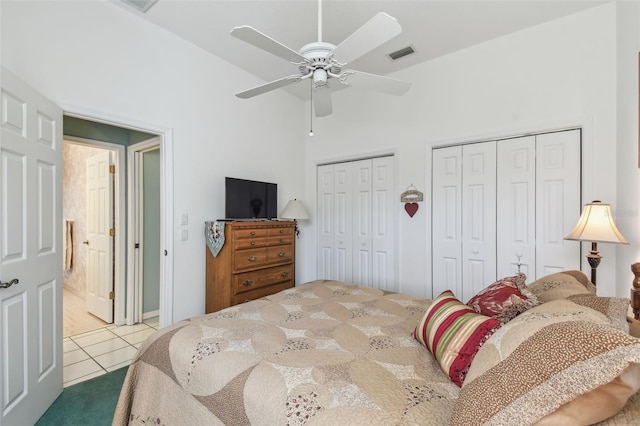 tiled bedroom featuring high vaulted ceiling, ceiling fan, visible vents, and two closets