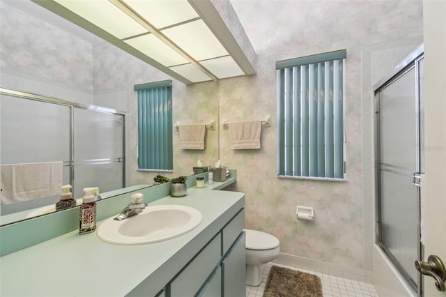 bathroom featuring toilet, vanity, baseboards, tile patterned floors, and wallpapered walls