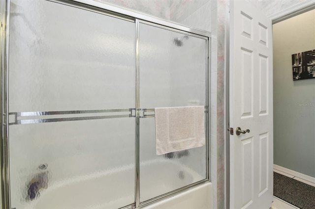 bathroom with shower / bath combination with glass door, baseboards, and tile patterned floors