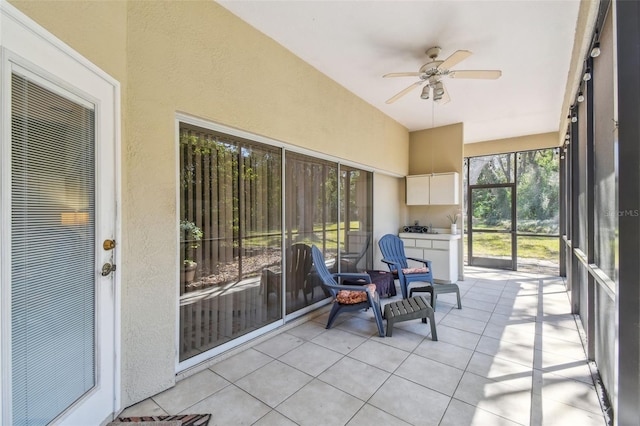 sunroom with vaulted ceiling and a ceiling fan