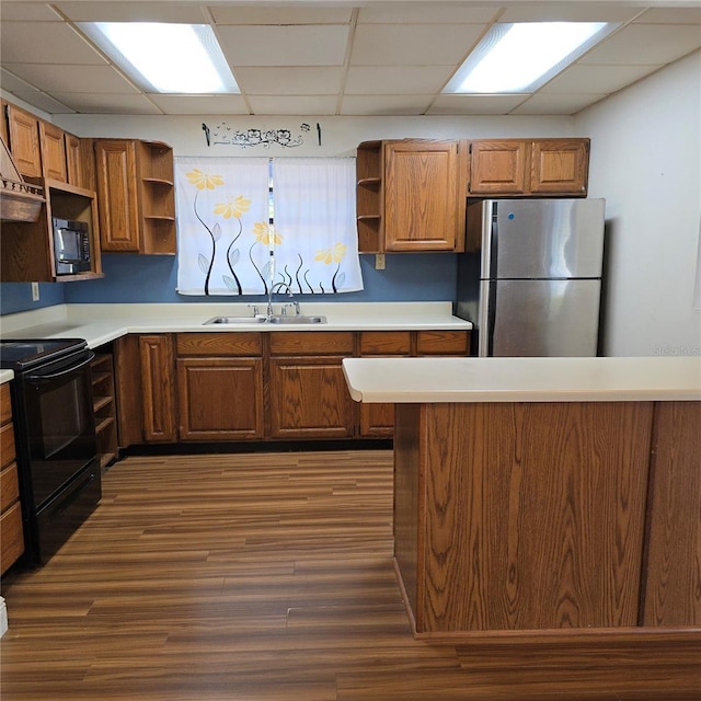 kitchen with dark wood-style flooring, open shelves, light countertops, a sink, and black appliances