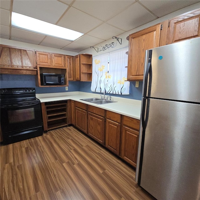 kitchen featuring open shelves, light countertops, dark wood-type flooring, a sink, and black appliances