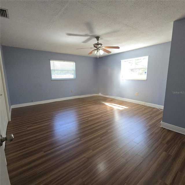 spare room featuring a textured ceiling, wood finished floors, and visible vents