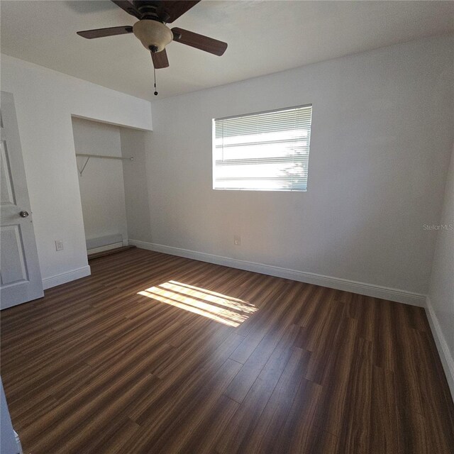 unfurnished bedroom featuring a closet, ceiling fan, baseboards, and wood finished floors