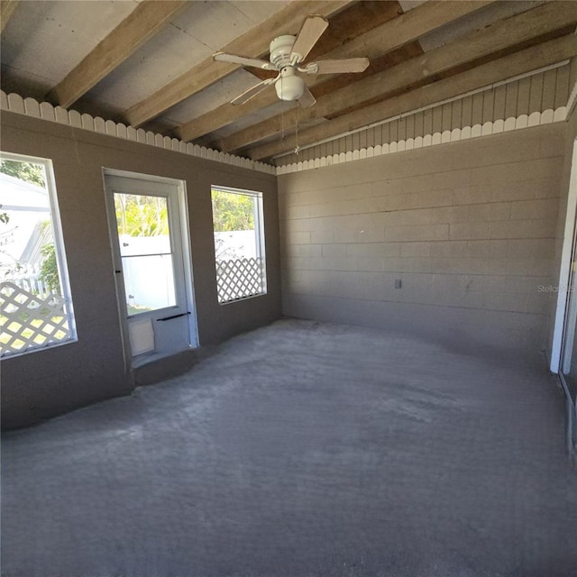 unfurnished sunroom featuring a ceiling fan