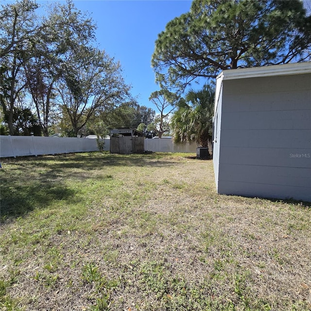 view of yard featuring fence and central AC unit