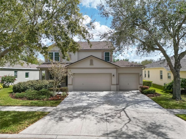 traditional-style house with a garage, a front yard, concrete driveway, and stucco siding