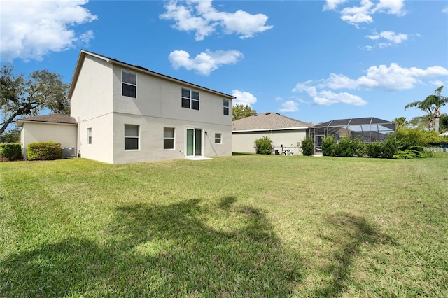 rear view of house featuring glass enclosure, central AC unit, stucco siding, and a yard