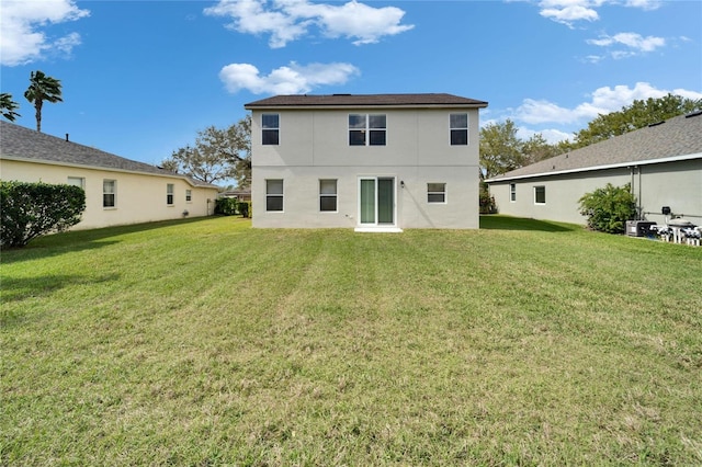 back of house featuring a yard and stucco siding