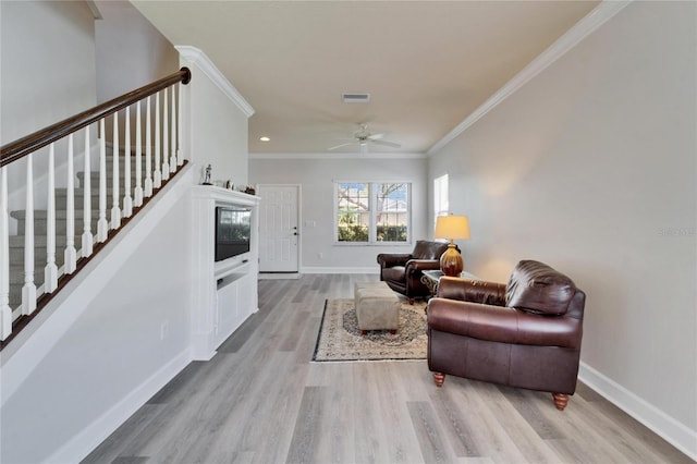 living area with light wood-style floors, crown molding, stairway, and baseboards