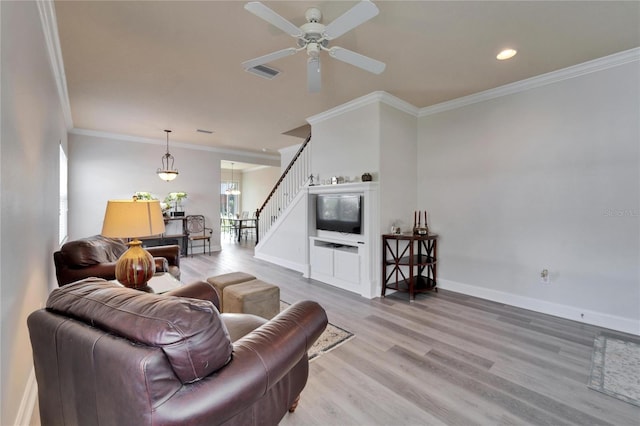 living area with visible vents, stairway, ornamental molding, wood finished floors, and baseboards