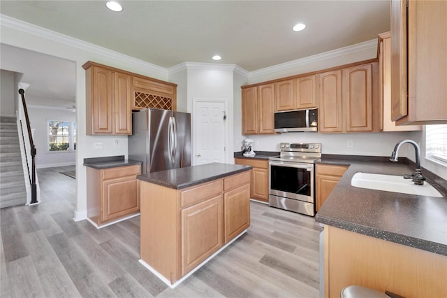 kitchen with stainless steel appliances, dark countertops, a sink, and crown molding