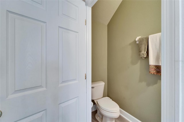 bathroom with toilet and baseboards