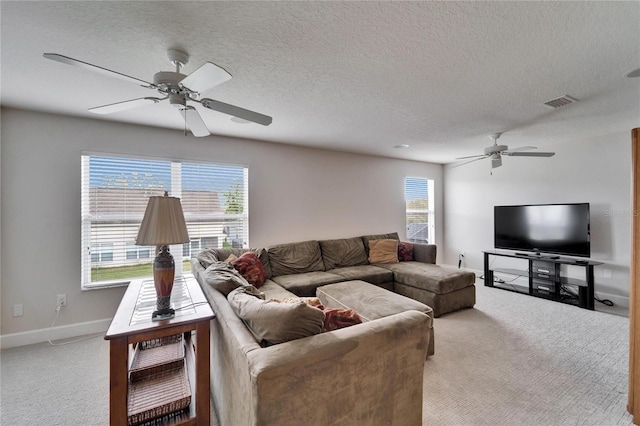 carpeted living area with a ceiling fan, baseboards, visible vents, and a textured ceiling