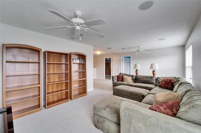 carpeted living room with a ceiling fan and a textured ceiling