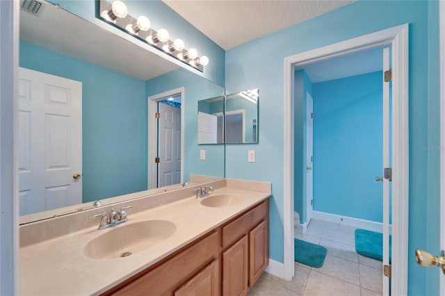 bathroom featuring toilet, tile patterned flooring, visible vents, and a sink