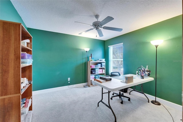 office space featuring a textured ceiling, carpet floors, a ceiling fan, and baseboards