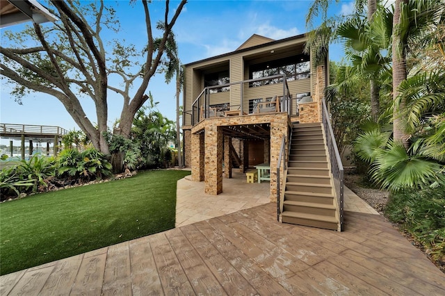 back of house with stairway, a lawn, and a patio