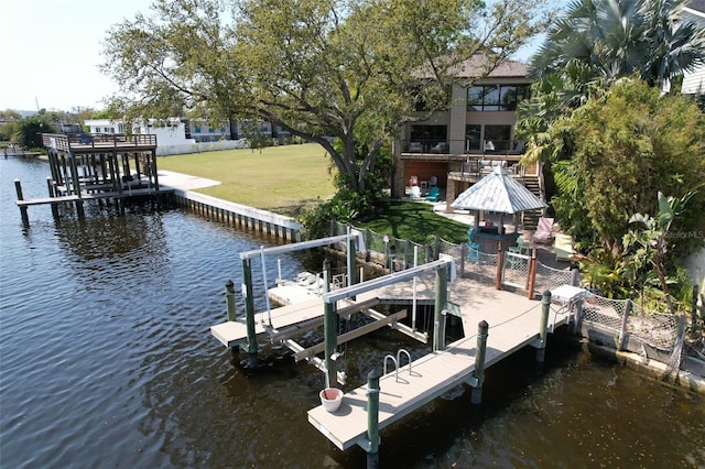 view of dock with a water view, a lawn, and boat lift