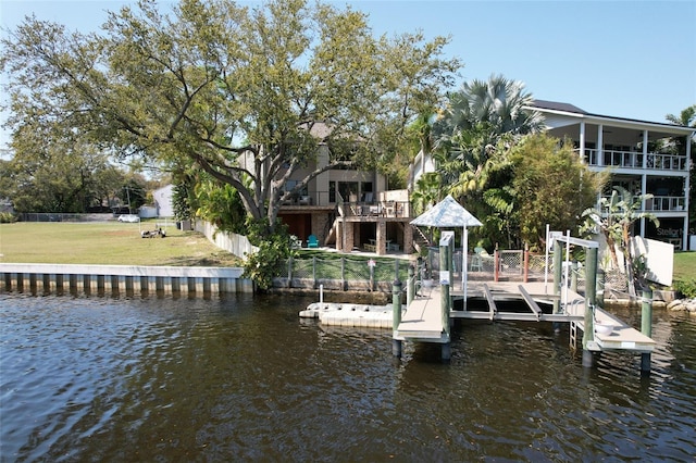 dock area with a water view, a lawn, boat lift, and stairs