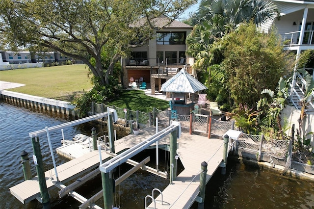 dock area with a water view, a yard, and boat lift